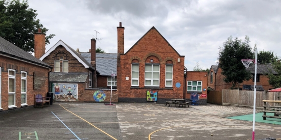 image of Claybrooke School, red brick building with chimneys and small playground