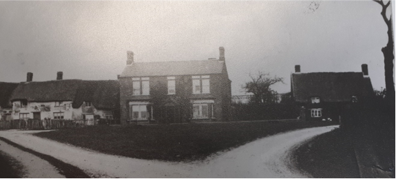 1910 image showing double-fronted Victorian house at a road junction.